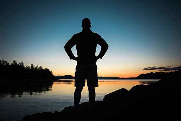 heroes needed | man standing looking at sunset