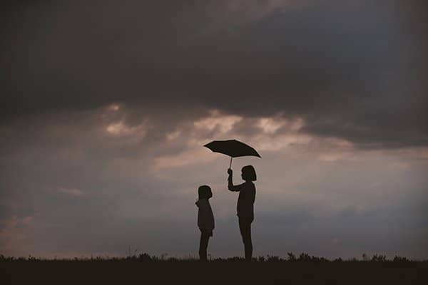 individuals help | woman with child umbrella