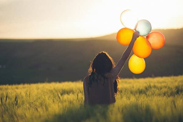virtue happiness | woman holding balloons