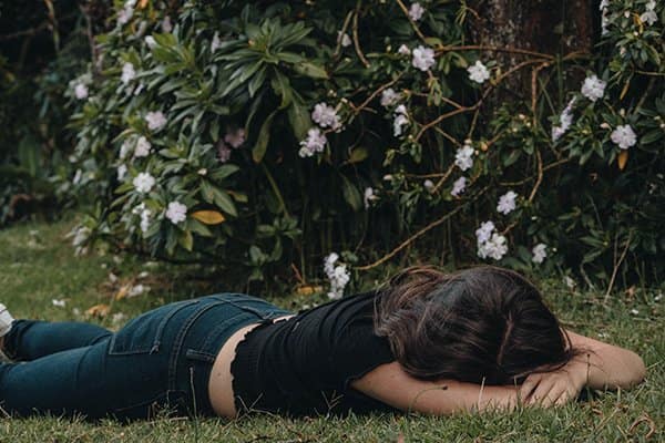 self-improvement self-attack | disappointed woman lying on grass