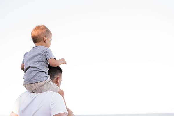 family | boy riding on father's shoulders