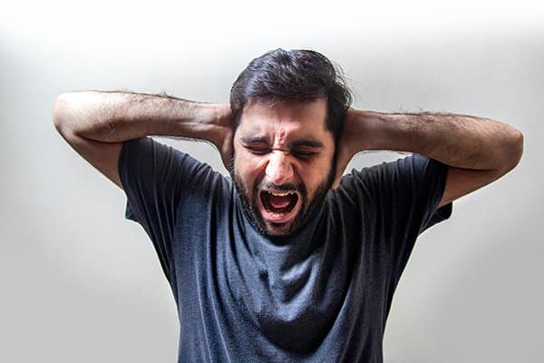 fear pain anxiety | man yelling with hands over ears