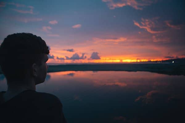 humility | young man staring at sunset