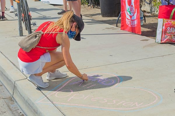 weaker society | woman writing on sidewalk